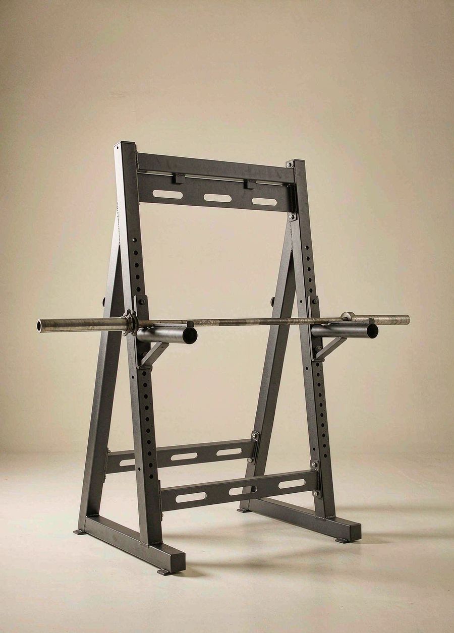 Xiaole two-post squat stand with spotter arms and a barbell, on a bone-coloured studio background.